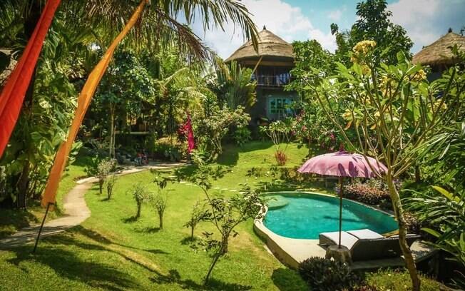 Casa na árvore com piscina e um lindo jardim tropical.