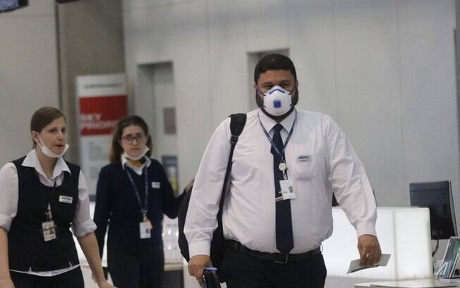 pessoas de máscara em aeroporto