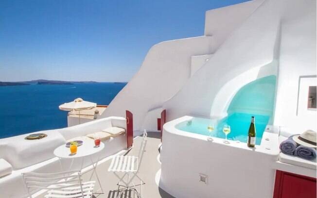 Casa em Santorini, Grécia. Com paredes brancas e uma piscina de água azul.