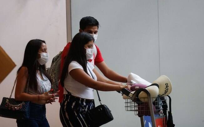 pessoas se protegendo do vírus utlizando mascaras.