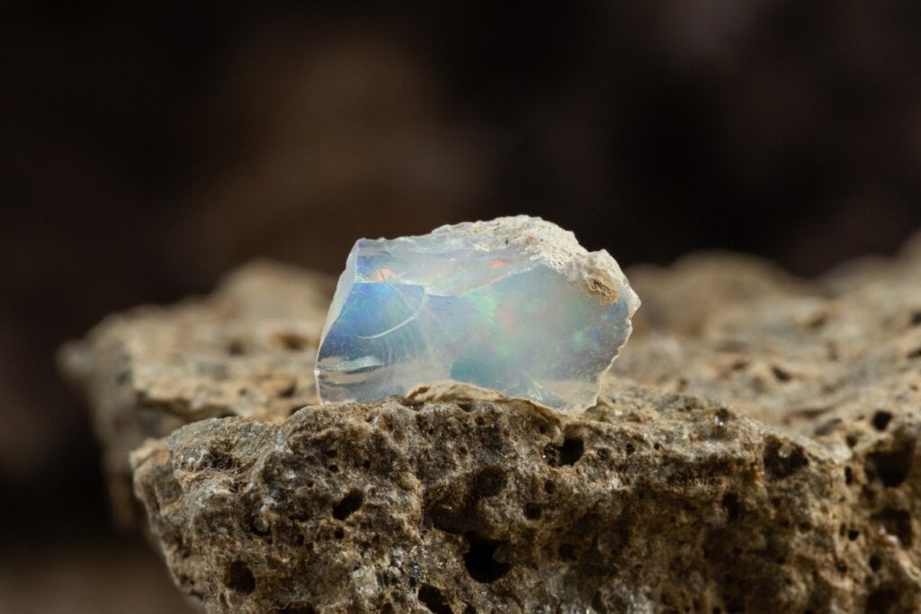 Pedra opala branca e azul em cima de uma rocha 