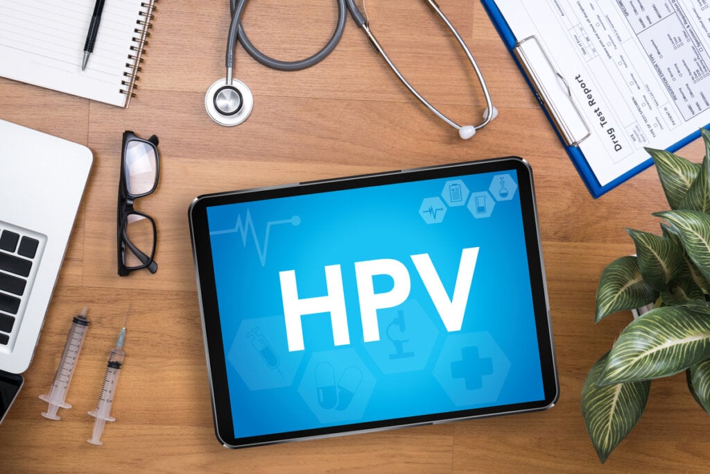 Tablet com sigla HPV em cima de mesa de madeira